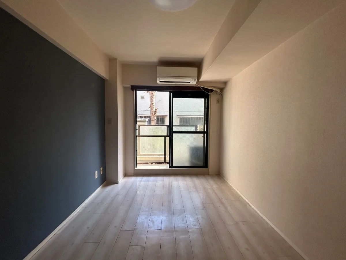 ワンルーム Before ネイビーアクセントクロスと濃色フローリング